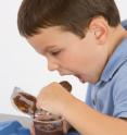 Niko Michos, 3, doesn't miss out on tasty food because of his food allergies. Here, he makes quick work of a dish of chocolate soy pudding.