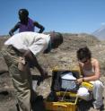 Purdue University graduate student Sarah D. Stamps and Tanzanian scientist Elifuraha Saria install a Global Positioning System instrument in the Natron area of Tanzania. The Ol Doinyo Lenga volcano is visible in the background. Global Positioning Systems were used by a Purdue-led team to capture the first dyking event ever recorded within the Earth's continental crust.