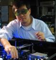 NIST physicist Jun Ye adjusts the laser setup for a strontium atomic clock at JILA, a joint institute of NIST and the University of Colorado at Boulder.