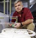 Waymond Scott, a professor in Georgia Tech's School of Electrical and Computer Engineering, positions a land mine in the test facility he built to evaluate and enhance sensors designed to detect buried land mines.