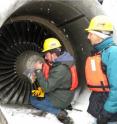 Mike Begier and Allen Gosser of USDA Wildlife Services pull feathers out of the plane's engines for use in forensic analysis.