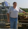 University of Missouri researcher Monty Kerley stands next to cattle preparing to eat. Kerley is studying how to raise cattle more efficiently and help farmers cut costs.