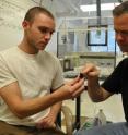 Geoscientists Chris Reinhard (left) and Timothy Lyons (right) of UC Riverside examine a 2.5 billion-year-old black shale from Western Australia. Reinhard, a graduate student, works in Lyons's laboratory.