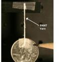 A yarn spun of boron-nitride nanotubes suspends a quarter. The nanotubes in this yarn were produced with a new technique discovered by researchers at NASA's Langley Research Center, the Department of Energy's Thomas Jefferson National Accelerator Facility and the National Institute of Aerospace. The nanotubes are highly crystalline and have a small diameter. They also structurally contain few walls and are very long.