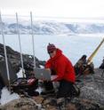 A member of the research team installs GPS equipment in Greenland.