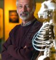 Dr. C. Owen Lovejoy, Kent State University professor of anthropology, stands next to the reconstructed skeleton of "Lucy," a near-complete fossil of a human ancestor that walked upright more than three million years ago. In October 2009, a team of researchers including Lovejoy unveiled research findings of a skeleton older than "Lucy," nicknamed "Ardi." "Ardi" has been named the Breakthrough of the Year.