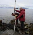 Michel Boufadel (right), director of the Center for Natural Resources Development and Protection in Temple's College of Engineering, places montioring equipment in a well dug along a beach in Alaska's Prince William Sound.  Boufadel found that the low concentrations of oxygen and nutrients, along with the flow of water in the beach's lower layer, were hindering the aerobic biodegradation of oil remaining from the Exxon Valdez spill.