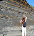 Monika Kodrans-Nsiah inspects an exposed section of the Kimmeridge Clay Formation on Dorset's "Jurassic Coast."