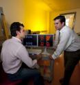 Hadi Shafiee, left, a Ph.D. candidate in engineering science and mechanics, and Rafael Davalos, assistant professor of biomedical engineering at Virginia Tech, discuss the experimental results of their work, displayed on the two screens.  They are developing a unique microsystem that is showing considerable promise for the detection of cancer and for the study of the progression of the disease.