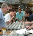 This is a photo of scientists on a 2003 deep sea expedition looking at a sediment core containing a record of a 65.5 million year old asteroid impact. Scripps paleoceanographer Richard Norris is third from left.