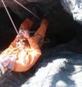 A student abseiling down a 25 m deep shaft 200 m away from the <i>sediba</i> site. This is what the less eroded cave systems look like near Malapa; narrow vertical shafts leading to sediment-choked subterranean chambers.