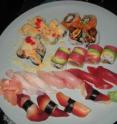 This is a plate of sushi with several pieces of tuna in the center (dark red is <i>akami</i>; light pink is <i>toro</i>).