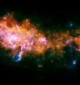 This image is taken looking towards a region of the galaxy in the Eagle constellation, closer to the galactic center than our sun. Here, we see the outstanding end-products of the stellar assembly line. At the center and the left of the image, the two massive star-forming regions G29.9 and W43 are clearly visible. These mini-starbursts are forming, as we speak, hundreds and hundreds of stars of all sizes: from those similar to our sun, to monsters several tens of times heavier than our sun.

These newborn large stars are catastrophically disrupting their original gas embryos by kicking away their surroundings and excavating giant cavities in the galaxy. This is clearly visible in the "fluffy chimney" below W43.