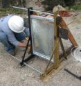 An engineer from the University of Missouri studies the glass pane after a test explosion.