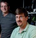 Mark Schnitzer, associate professor of biology and applied physics, right, and Juergen Jung, operations director of the Schnitzer lab, in front of the microscope setup used to image the deep brain.