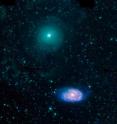 This three-color image of NGC 470 (top) and NGC 474 (bottom) shows far-UV emission from young stars observed by GALEX in blue, heated dust mid-infrared emission observed by Spitzer in red, and stellar near-infrared emission observed by Spitzer in green. These galaxies are likely to be on their first pass past each other and are therefore relatively undisturbed at a separation of 160,000 light-years.