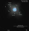 This illustration is a composite of numerous separate Hubble WFC3 images. A color image composed of exposures made through three color filters shows the disk of Neptune, revealing clouds in its atmosphere. 48 separate images from a single filter were brightened to reveal the very faint moons. The white dots are Neptune's inner moons moving along their orbits during Hubble's observations. The solid green lines trace the full orbit of each moon. The spacing of the moon images follows the timing of each Hubble exposure. About 30 moons are known to orbit Neptune, most of which are too faint or orbit too far away to appear in these images.