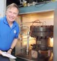 Paul Steffes, a professor in Georgia Tech's School of Electrical and Computer Engineering, poses with a pressure vessel used to simulate the atmosphere of Jupiter.  The information from the simulations will be used to interpret data sent back by the Juno Mission.