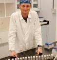 ASU graduate student Greg Brennecka stands in the W.M. Keck Foundation Laboratory for Environmental Biogeochemistry at ASU in front of the powdered carbonate rock samples collected in Dawen, Southern China. These samples are prior to chemical processing to ready for measurement on the mass spectrometer. There were about 40 samples total for this study.