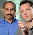 Georgia Tech School of Mechanical Engineering professor Suresh Sitaraman (left) and doctoral student Gregory Ostrowicki examine a specimen scheduled for analysis using the magnetically actuated peel test. An enlarged image of the specimen is shown behind them.