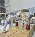 The MIRI Cleanroom Huddle: Although it appears that these six contamination control engineers are in a huddle around the James Webb Space Telescope's Mid-Infrared Instrument (or MIRI), they are conducting a receiving inspection. Engineers from the European Space Agency are wearing blue hoods, and engineers from NASA's Goddard Space Flight Center are wearing the white hoods. As part of the standard receiving inspection, they are looking for the tiniest traces of dust or contamination which would have to be remedied because cleanliness is a priority for such a sensitive instrument; MIRI passed its inspection review.