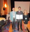 Members of the conference organizing committee, Wolfgang Hansen, far left, of Technische Universitat Dresden, Germany, and Sama Bilbao y Leon, right, of Virginia Commonwealth University, congratulate Reza Arghandeh, middle, Virginia Tech doctoral candidate in electrical and computer engineering, for winning the international best paper award.