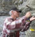 Along sea cliffs in southern England, geologist Paul Olsen of Columbia University's Lamont-Doherty Earth Observatory samples rocks from near the 201,564,000-year Triassic extinction boundary.