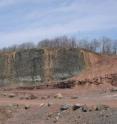 In Clifton, New Jersey, a massive basalt flow (black rock on left) from the time of the End Triassic is exposed in a former quarry, now located behind a retirement home. Reddish sedimentary rocks signaling the extinction itself lie to the far right.