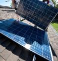 Brian Webster (left) and Mario Richard install photovoltaic (PV) modules on an Englewood, Colo., home. Manufacturing and installing solar panels require large amounts of electricity. But Stanford scientists have found that the global PV industry likely produces more electricity than it consumes.