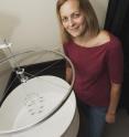 Lead study author Anna Greenwood, Ph.D., is next to the device used for the study, made from an old bicycle wheel and other salvaged parts.