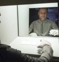 Kevin Houser, Professor of Architectural Engineering at Penn State, sorts cards in a light box in the departments illuminating engineering lab for observation under several light sources.