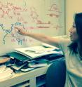 Stanford Chemical Engineering Professor Zhenan Bao points to a diagram of a rubber molecule, indicating the springy feature exploited by her team's wireless pressure sensor.