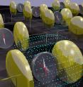 This is a conceptual illustration of how magnetism is reversed (see compass) by the application of an electric field (blue dots) applied across gold capacitors. Blurring of compass needle under electric field represents two-step process.