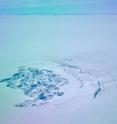 In April 2014, researchers flew over a site in southwest Greenland to find that a sub-glacial lake had drained away. This photo shows the crater left behind, as well as a deep crack in the ice.