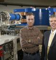 Purdue University professors Darryl Granger (left) and Marc Caffee stand in front of the gas-filled magnet detector in the Purdue Rare Isotope Measurement Laboratory. The detector was used to date the Little Foot skeleton.