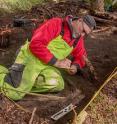 Dave McMahan, Neva Project principal investigator, takes notes in a completed excavation block.