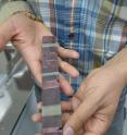 Aaron Satkoski, a scientist in the UW-Madison Geoscience Department, holds a sample sawn from a 3.23-billion-year-old rock core sample found in South Africa. The bands show different types of sediment falling to the ocean floor and solidifying into rock. The sample provides the earliest known evidence for oxygenic photosynthesis.