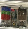 A view of the contents of two of Strata-1's tubes. The regolith simulant on the left is a simplified model consisting of angular fragments of colored glass, sorted into three sizes. The tube on the right contains pulverized meteorite material to closely resemble the actual regolith on a small asteroid, also sorted into three sizes.
