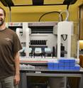 Morandin and Mikheyev pictured at OIST with the robot that helped prepared the samples for sequencing.