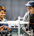 UW mechanical engineering doctoral students Amey Khanolkar and Morgan Hiraiwa prepare to analyze microscale granular crystal dynamics in an ultrasonic laser setup.