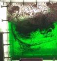 Snapshots of the same box box, filled with a green syrup as well as bubbles and plastic flakes (grey color), used to study magma in volcanoes.  Researchers place the box on top of a specialized shaking table where it first rests (left) and then shakes side-to-side (right).