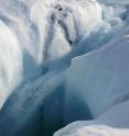 Melt water pours through a channel in Greenland's ice.