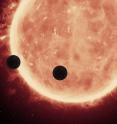 Artist's view of planets transiting a red dwarf star in the TRAPPIST-1 system.