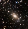 This view of a massive cluster of galaxies unveils a very cluttered-looking universe filled with galaxies near and far. Some are distorted like a funhouse mirror through a "space warp" phenomenon first predicted by Einstein a century ago.