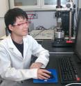 Rice University physicist Ching-Hwa Kiang, left, and graduate student Jingqiang Li analyze readings at the atomic force microscope in her lab. The researchers analyzed the properties of carbon nanoribbons in solutions with the equipment they normally use to analyze DNA, proteins and cells.