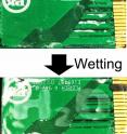 A coating on a circuit board is unobservable when dry (top) but wrinkles to display 'H<sub>2</sub>O' when exposed to moisture (bottom).