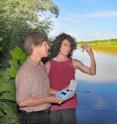 Sandia researchers May Nyman and Tom Stewart take a water sample on the banks of the Rio Grande. The two developed a patent-applied-for, material-based approach to purifying water that has generated commercial interest.