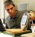 Professor Yuval Goren demonstrates the portable X-ray device on an ancient tablet.