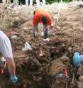 Workers examine remains at a mass grave in eastern Bosnia in 2004. This week at a scientific conference in Canc&#250;n, Mexico, scientists will discuss their research into using of geophysical techniques to seek hidden mass graves of atrocity victims.