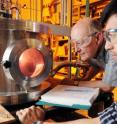 Georgia Tech professor Dennis Hess and graduate research assistant Lester Li observe oxygen plasma treatment that exposes the cellulose nanofibrils on their superamphiphobic paper samples.